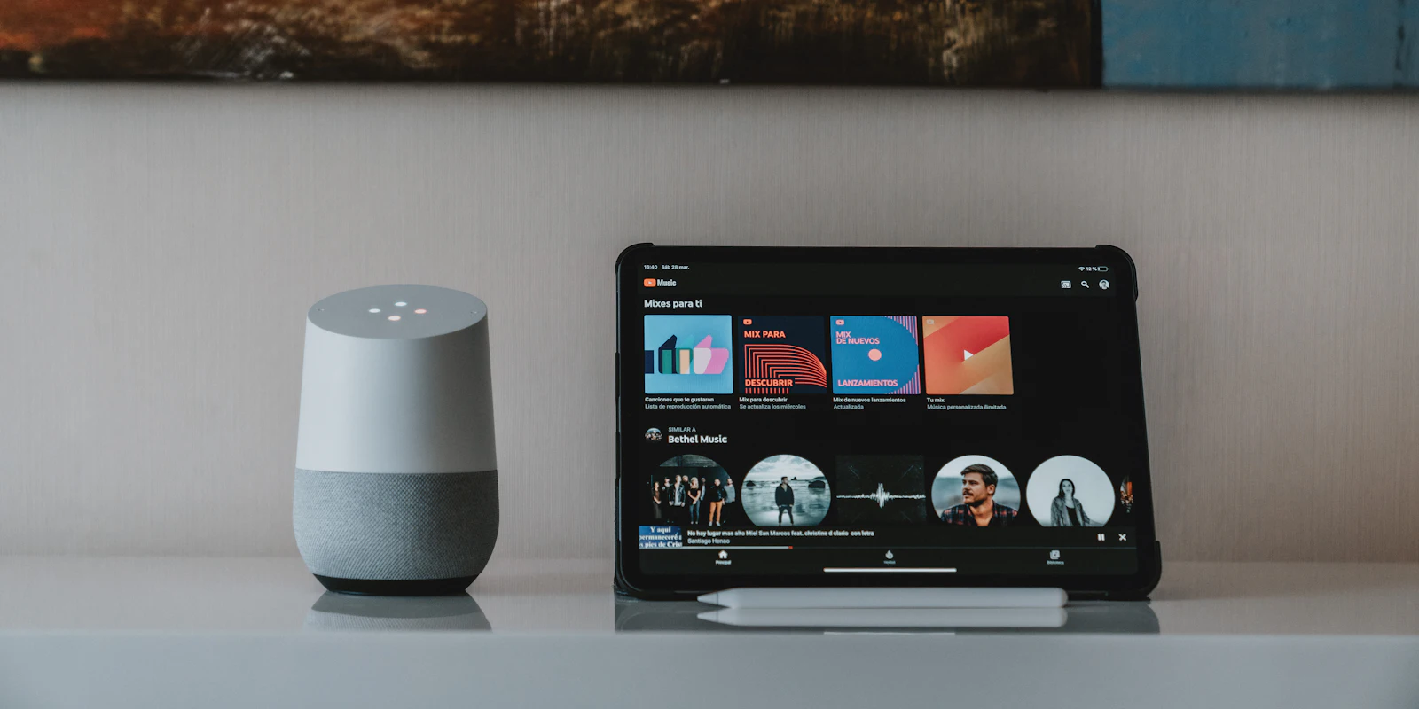 Smart speaker next to a tablet showing a smart home dashboard