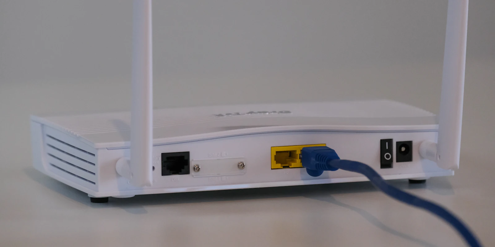 White Wi-Fi router with network cables plugged into the back